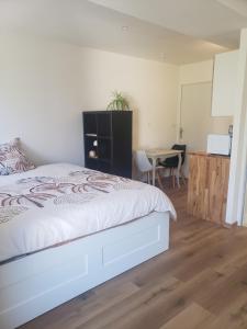 a bedroom with a white bed and a table at studio entièrement équipé 