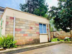 a brick house with a blue window on it at Neitu Shalom Nest in Eldoret