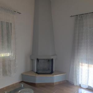 a living room with a tv in the corner of a room at Trikala Groundhouse in Rizareión