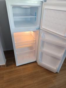 an empty refrigerator with its door open in a kitchen at Trikala Groundhouse in Rizareión