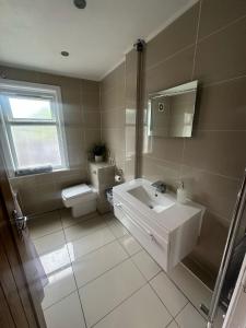a bathroom with a toilet and a sink at Comfortable cosy one bed flat with garden in se London in Elmers End +3 photos