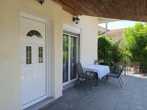 a white door with a table and chairs on a patio at Trikala Groundhouse in Rizareión