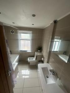 a bathroom with a tub and a sink and a toilet at Comfortable cosy one bed flat with garden in se London in Elmers End