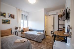 a bedroom with two beds and a desk and a table at Къща за гости ЕМА in Vetren Dol
