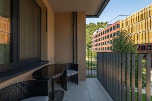 a balcony with a table and chairs and a building at Riverside luxury apartment in Bratislava
