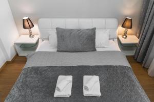 a bedroom with a large white bed with two lamps at Riverside luxury apartment in Bratislava