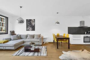 a white living room with a couch and a table at Riverside luxury apartment in Bratislava