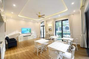 a room with tables and chairs and a flat screen tv at Liséa Wonderland Resort Deluxe Bedrooms by Private Beach in Xuyên Mộc