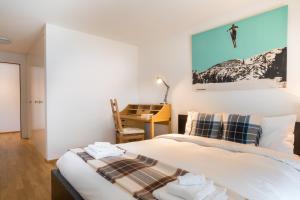 a bedroom with a bed and a desk at Holzgasse Apartment in Andermatt