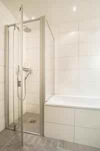 a bathroom with a shower and a bath tub at Holzgasse Apartment in Andermatt +25 photos