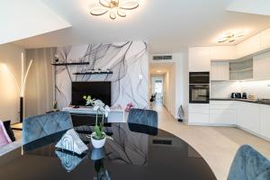 a kitchen and living room with a table and chairs at Hajnal Residence Deluxe with Terrace by Mital in Szeged