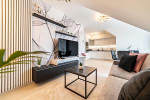 a living room with a couch and a tv at Hajnal Residence Deluxe with Terrace by Mital in Szeged