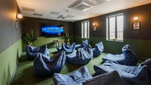 a room with blue chairs and a flat screen tv at Students Only Straits Egham - 40 mins to Waterloo - Direct Bus to Heathrow in Egham
