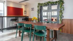a dining room with a table and green chairs at Students Only Straits Egham - 40 mins to Waterloo - Direct Bus to Heathrow in Egham +18 photos