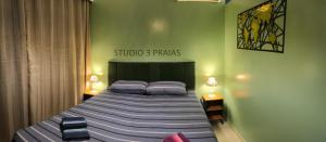 a bedroom with a large bed with blue pillows at Studio 3 Praias in São Vicente +24 photos