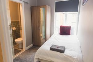 una camera da letto con un letto con un cuscino rosso sopra di LYNNTON HOUSE Stunning 6 bed Town Centre House ALL with En-Suites Prime Location Tamworth a Tamworth Altre 34 foto