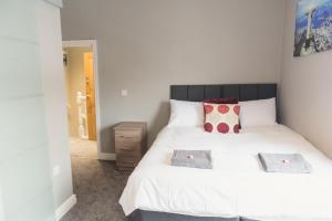 una camera con un letto bianco con due cuscini di LYNNTON HOUSE Stunning 6 bed Town Centre House ALL with En-Suites Prime Location Tamworth a Tamworth