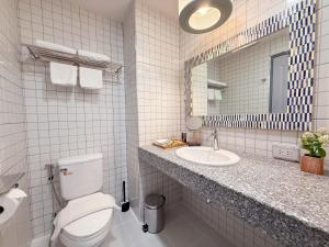 Un baño blanco con inodoro y lavabo. en Casa Klang Wiang, en Chiang Mai