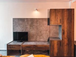 a living room with a tv and a wooden desk at Hotel City Center in Braşov