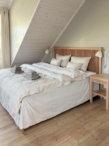 a bedroom with a large bed with a wooden headboard at Stylish Villa - Boat, Greenhouse & Majestic Oaks in Sørvåg