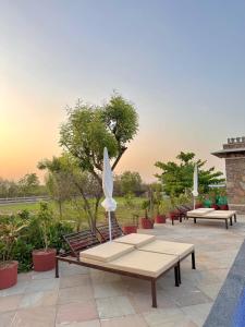 a group of benches with umbrellas on a patio at CABANA- 5 BHK Luxury Villa near Udaipur in Dabok