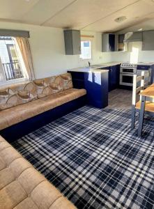 a living room with a couch and a kitchen at Willows 105 Caravan - 7 Lakes in Crowle