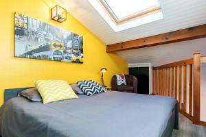 Le Duplex Lemon - Séjour Acidulé Proche Centre في مونت دي مارسان: غرفة نوم بها سرير بجدران صفراء وفتحة سقف +5 صور