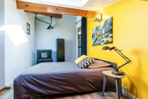 Le Duplex Lemon - Séjour Acidulé Proche Centre في مونت دي مارسان: غرفة نوم بسرير وجدار اصفر