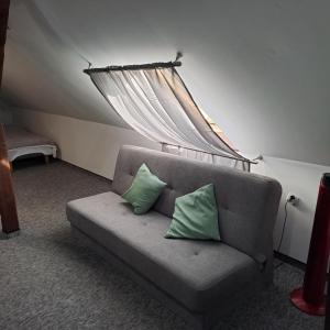 eine Couch mit zwei grünen Kissen in einem Zimmer in der Unterkunft Apartament nr 11 in Karpacz