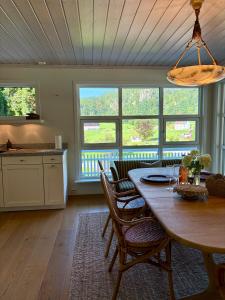 a kitchen and dining room with a table and chairs at Stylish Villa - Boat, Greenhouse & Majestic Oaks in Sørvåg