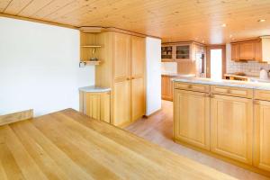 a kitchen with wooden cabinets and a wooden counter top at HOSPENTAL Chalet in Hospental