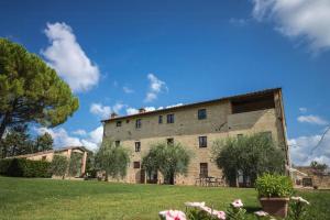 an external view of a large stone building with a yard at Historic Farmhouse Overlooking San Gimignano in San Gimignano +12 photos