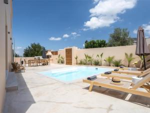 a backyard with a swimming pool and patio furniture at Roots Villa in Skinés