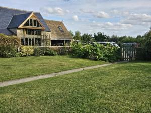 a house with a fence in a yard at The Farmhouse in Meysey Hampton