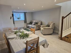 a living room with a table and chairs and a couch at The Farmhouse in Meysey Hampton