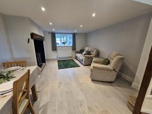 a living room with two chairs and a couch at The Farmhouse in Meysey Hampton