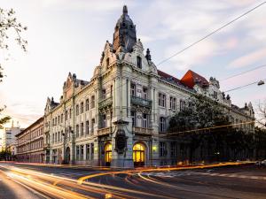 an old building on a city street with cars at Hajnal Residence Deluxe with Terrace by Mital in Szeged