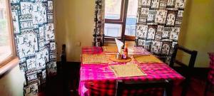 a table with a pink table cloth and a window at Africa Sky Lodge, Bar and Restaurant in Karatu