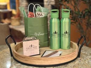 two green bottles on a table with a bag at Tree Top Mountain Lodge in Cullowhee