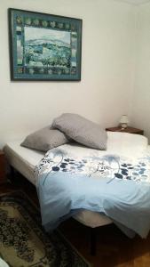 a bed in a bedroom with a picture on the wall at Butul Apartment in Koper