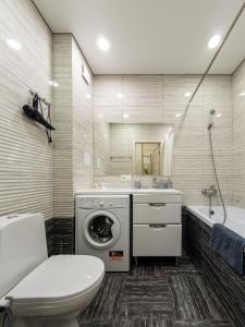 a bathroom with a washing machine and a toilet at Апартамент на Тулебаева! in Zhezdi
