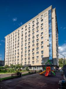 a large building with a playground in front of it at Апартамент на Тулебаева! in Zhezdi