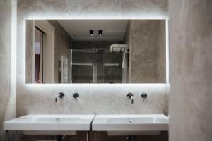 a bathroom with two sinks and a large mirror at Central Suites in Chieti