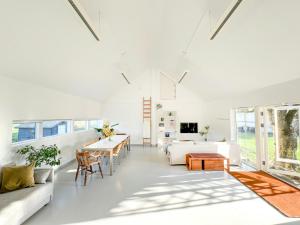 a living room with white furniture and a table at Lovely "Studio Solbakke" At Asmaløy, Hvaler in Rød