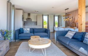 Una sala de estar con sofás azules y una mesa. en 4 Bedroom Stunning Home In Kamperland, en Kamperland