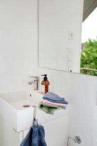a bathroom with a sink and a mirror and towels at Lovely "Studio Solbakke" At Asmaløy, Hvaler in Rød