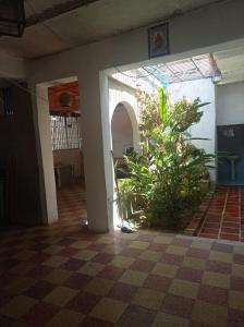 a room with a checkered floor and a plant at AGUITA SALÁ MALECON DE CHORONI 8c in Puerto Colombia