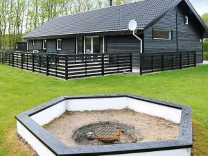 a house with a fire pit in the yard at 4 star holiday home in Storvorde in Storvorde