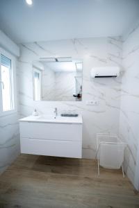 Un baño blanco con lavabo y espejo. en Nido PADRON, en Padrón