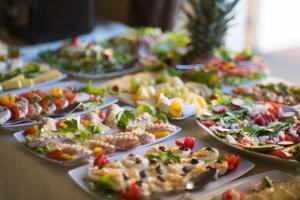 una mesa llena de diferentes tipos de comida en platos en Pensjonat Dolce Vita & SPA, en Ustronie Morskie